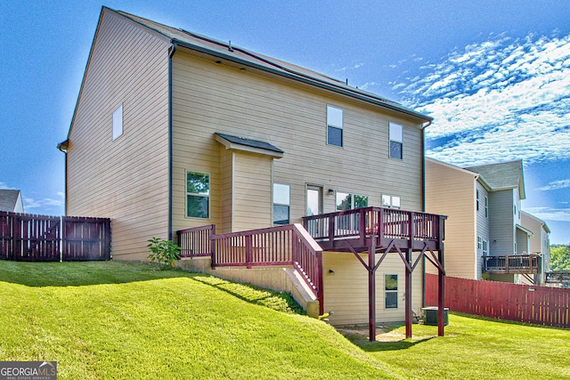 rear view of house with a lawn and a deck