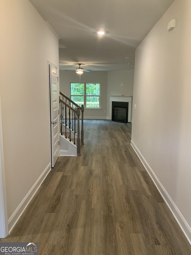 unfurnished living room with hardwood / wood-style floors, ceiling fan with notable chandelier, ornamental molding, and sink