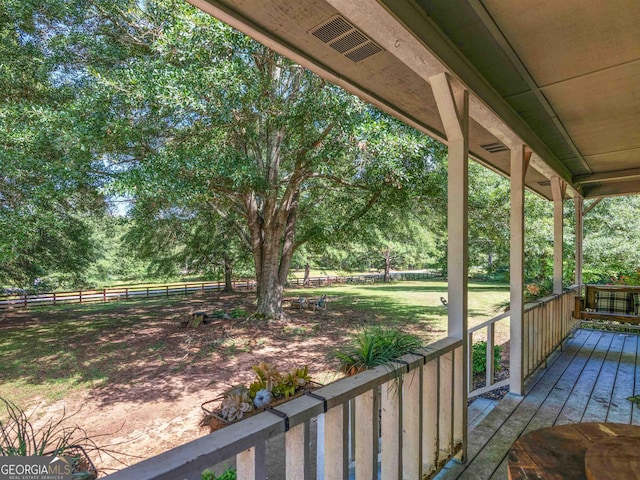 wooden deck with covered porch, visible vents, and fence