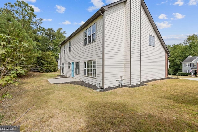 view of side of property featuring a patio area and a yard