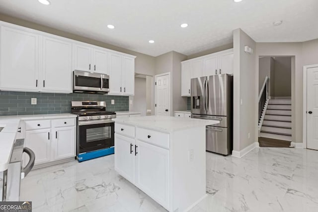 kitchen with tasteful backsplash, a kitchen island, light stone counters, white cabinetry, and stainless steel appliances