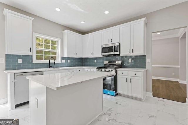 kitchen with white cabinetry, a center island, sink, stainless steel appliances, and light stone counters