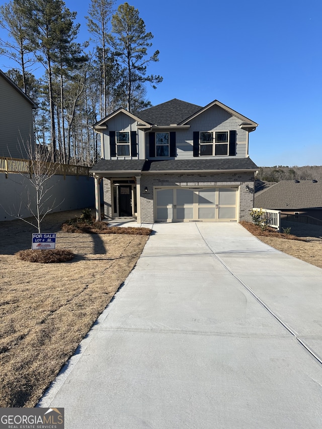 view of front of house with roof with shingles, brick siding, fence, a garage, and driveway