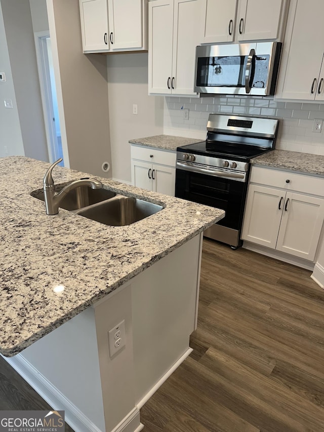 kitchen with stainless steel appliances, dark wood-type flooring, a sink, and white cabinetry