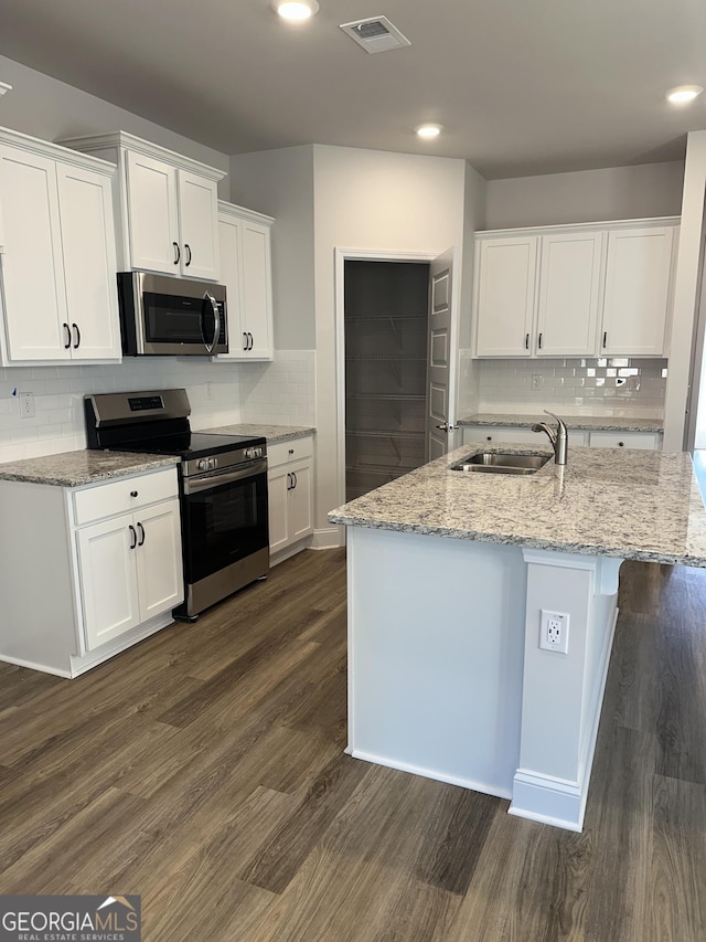 kitchen with visible vents, dark wood finished floors, appliances with stainless steel finishes, white cabinetry, and a sink