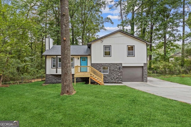 tri-level home featuring a garage and a front yard