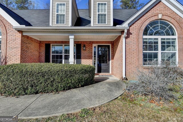 doorway to property featuring brick siding