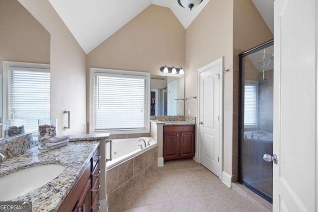 bathroom featuring vanity, a healthy amount of sunlight, shower with separate bathtub, and vaulted ceiling