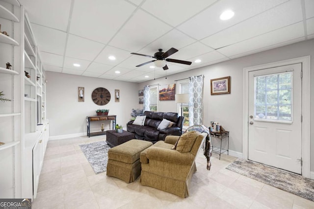 living room with built in shelves and ceiling fan