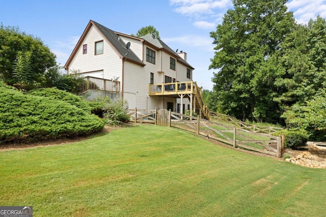 back of property with a yard and a wooden deck