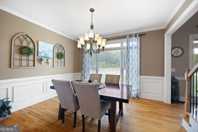 dining space featuring light hardwood / wood-style floors, a notable chandelier, and ornamental molding