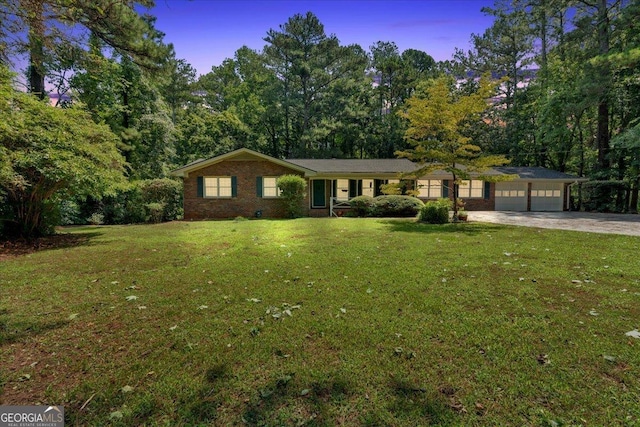 ranch-style house with a yard and a garage