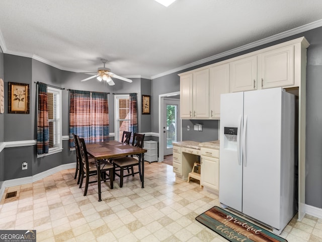 kitchen featuring a textured ceiling, ceiling fan, white refrigerator with ice dispenser, and crown molding