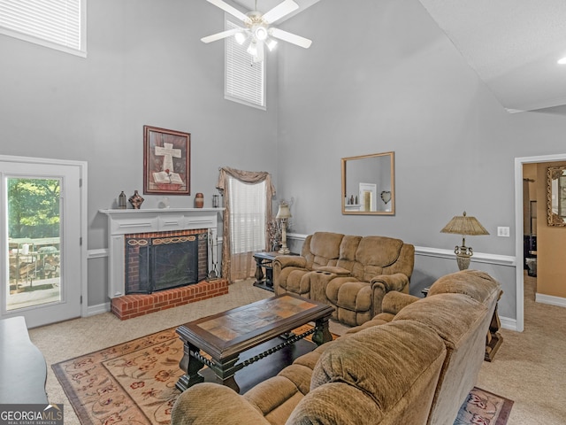 living room with ceiling fan, a fireplace, high vaulted ceiling, and light carpet