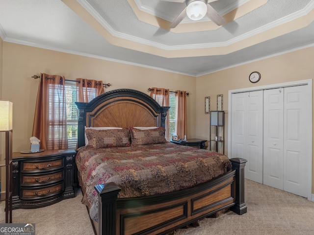 bedroom with a tray ceiling, multiple windows, ceiling fan, and light carpet