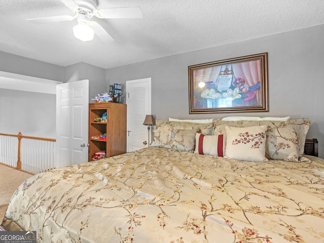 bedroom with ceiling fan, carpet floors, a textured ceiling, and a closet