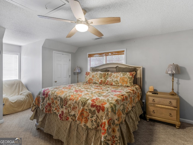 carpeted bedroom with ceiling fan, lofted ceiling, and a textured ceiling