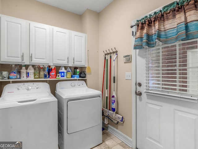 washroom with cabinets and washing machine and clothes dryer