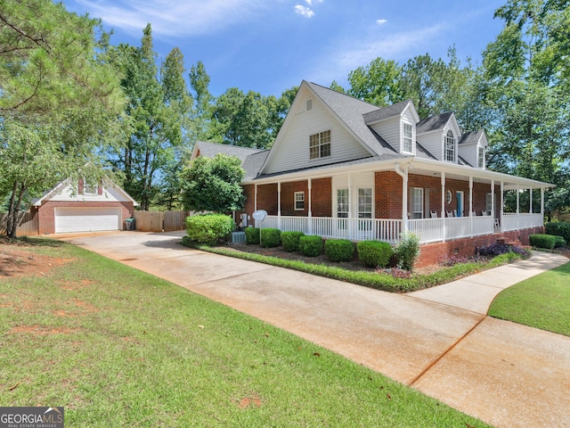 view of front of house with a porch, a garage, an outbuilding, and a front lawn