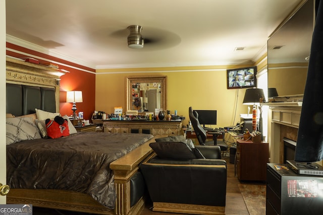 bedroom with ceiling fan, crown molding, a premium fireplace, and wood-type flooring