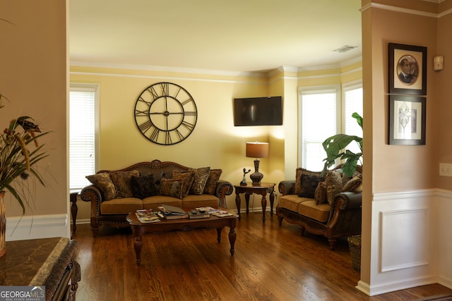 living room with wood-type flooring, ornamental molding, and a wealth of natural light