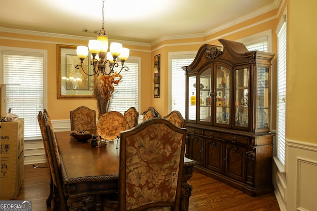 dining area with dark hardwood / wood-style flooring, crown molding, a wealth of natural light, and an inviting chandelier