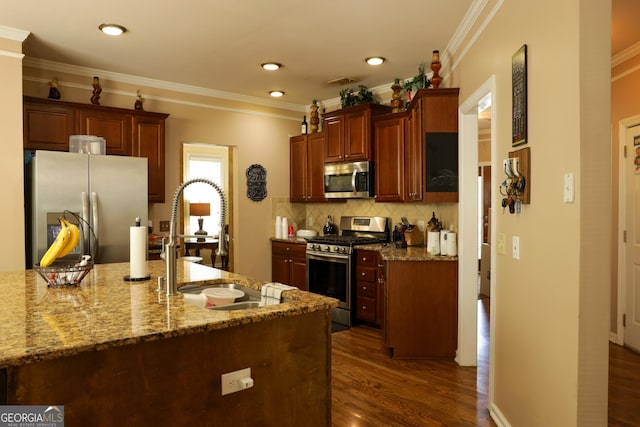 kitchen with backsplash, sink, light stone countertops, appliances with stainless steel finishes, and dark hardwood / wood-style flooring