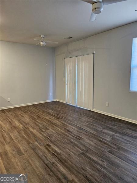 spare room with dark hardwood / wood-style flooring and ceiling fan