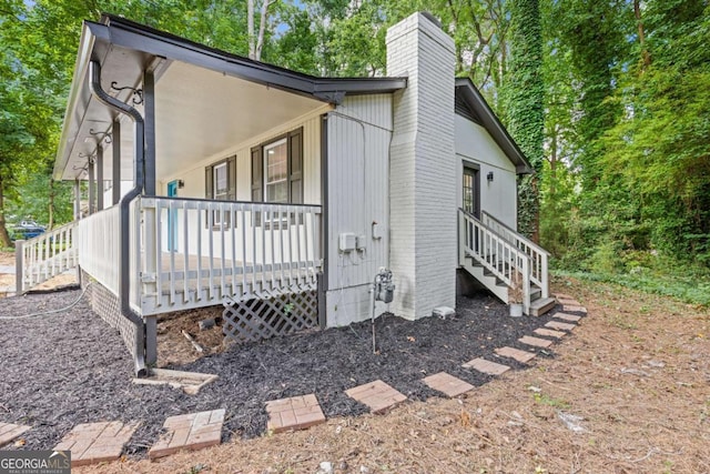 view of side of home featuring covered porch