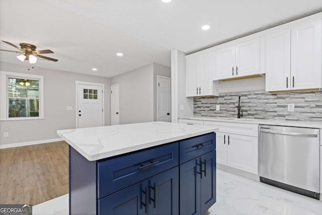 kitchen featuring stainless steel dishwasher, light stone counters, ceiling fan, white cabinets, and a center island