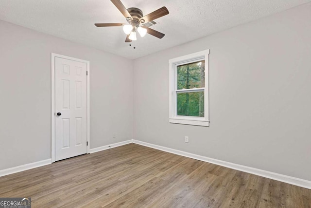 spare room featuring hardwood / wood-style floors, ceiling fan, and a textured ceiling