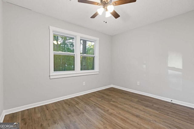 spare room with ceiling fan and dark wood-type flooring