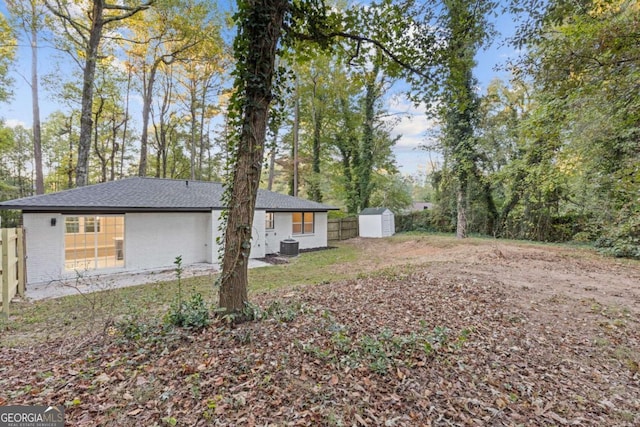 view of yard with central AC and a shed