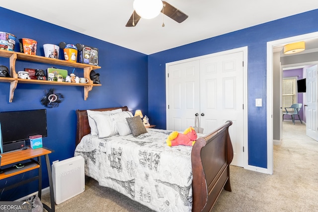 carpeted bedroom with ceiling fan and a closet