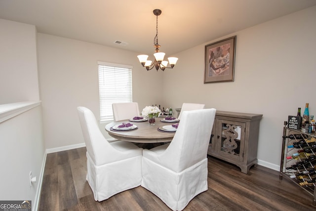 dining area with dark hardwood / wood-style flooring and a chandelier