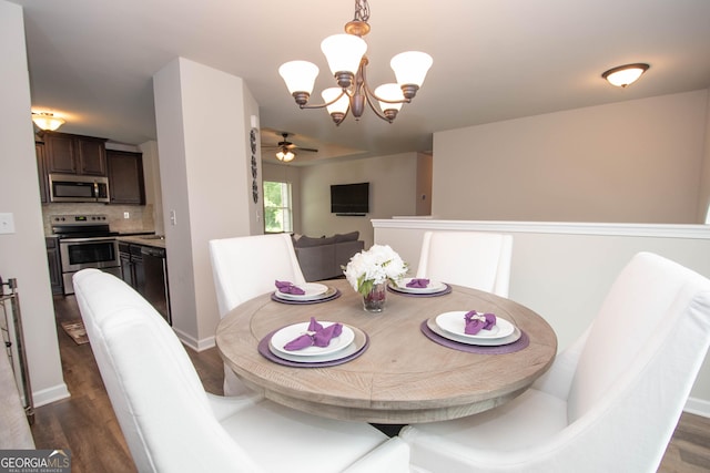 dining area with dark hardwood / wood-style floors and ceiling fan with notable chandelier