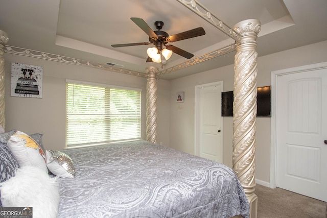 carpeted bedroom with ceiling fan and a raised ceiling