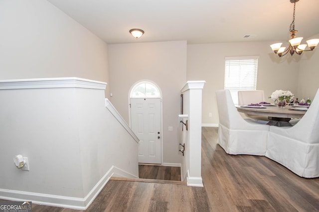 foyer featuring dark wood-type flooring and an inviting chandelier