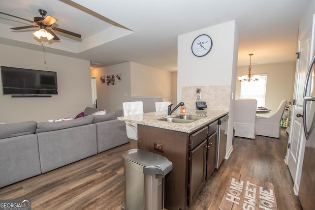 kitchen with dishwasher, dark wood-type flooring, sink, decorative light fixtures, and dark brown cabinetry