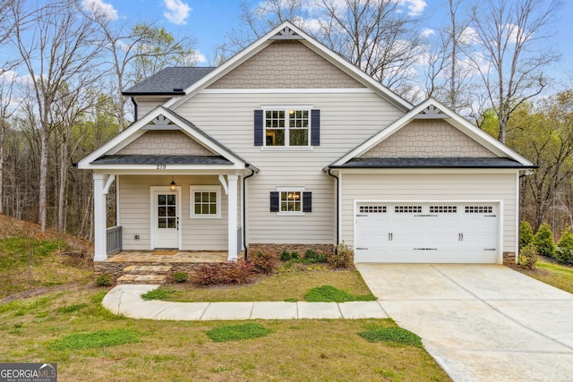 craftsman house with a garage, covered porch, and a front yard