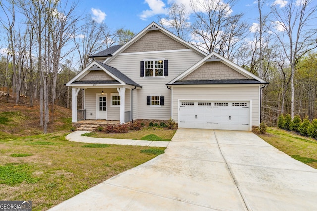 craftsman house featuring a front lawn, covered porch, and a garage