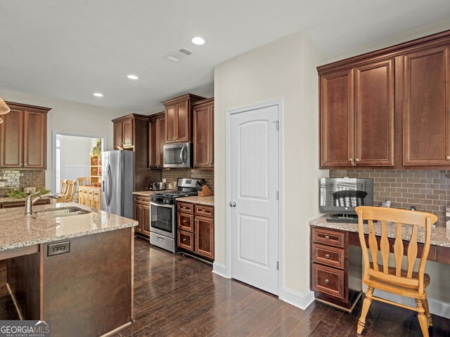 kitchen featuring decorative backsplash, sink, light stone countertops, and stainless steel appliances