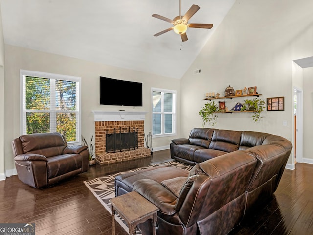 living room with ceiling fan, dark hardwood / wood-style floors, high vaulted ceiling, and a brick fireplace