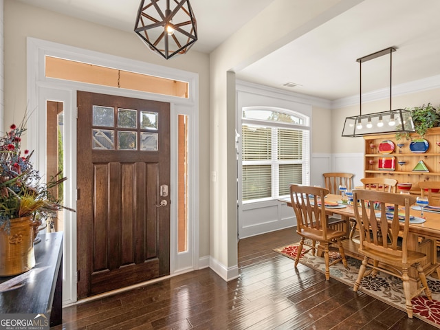 foyer featuring ornamental molding and dark wood-type flooring