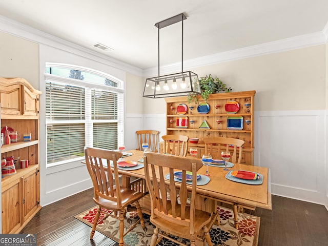 dining room with dark hardwood / wood-style flooring and crown molding