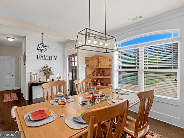 dining area featuring ornamental molding and dark wood-type flooring