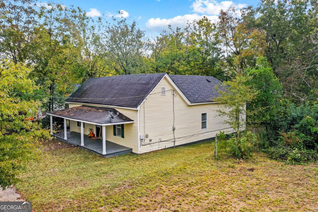 rear view of property with a patio and a lawn