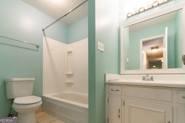 full bathroom featuring washtub / shower combination, toilet, a textured ceiling, vanity, and tile patterned flooring