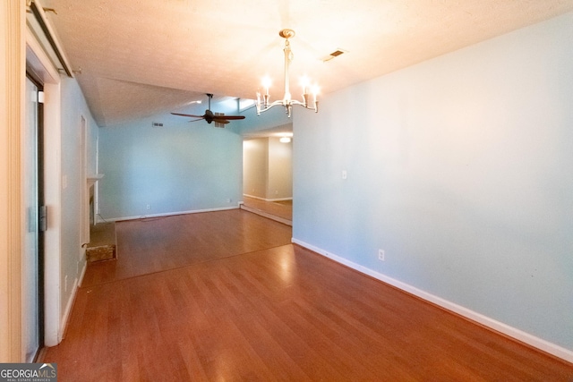 empty room featuring wood-type flooring and ceiling fan with notable chandelier