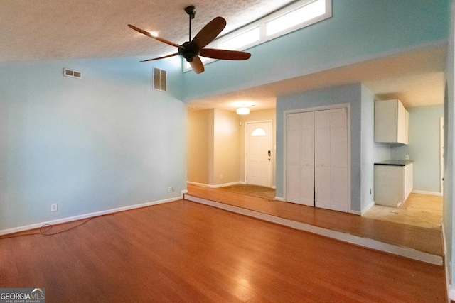 unfurnished living room featuring ceiling fan, lofted ceiling, and light hardwood / wood-style flooring